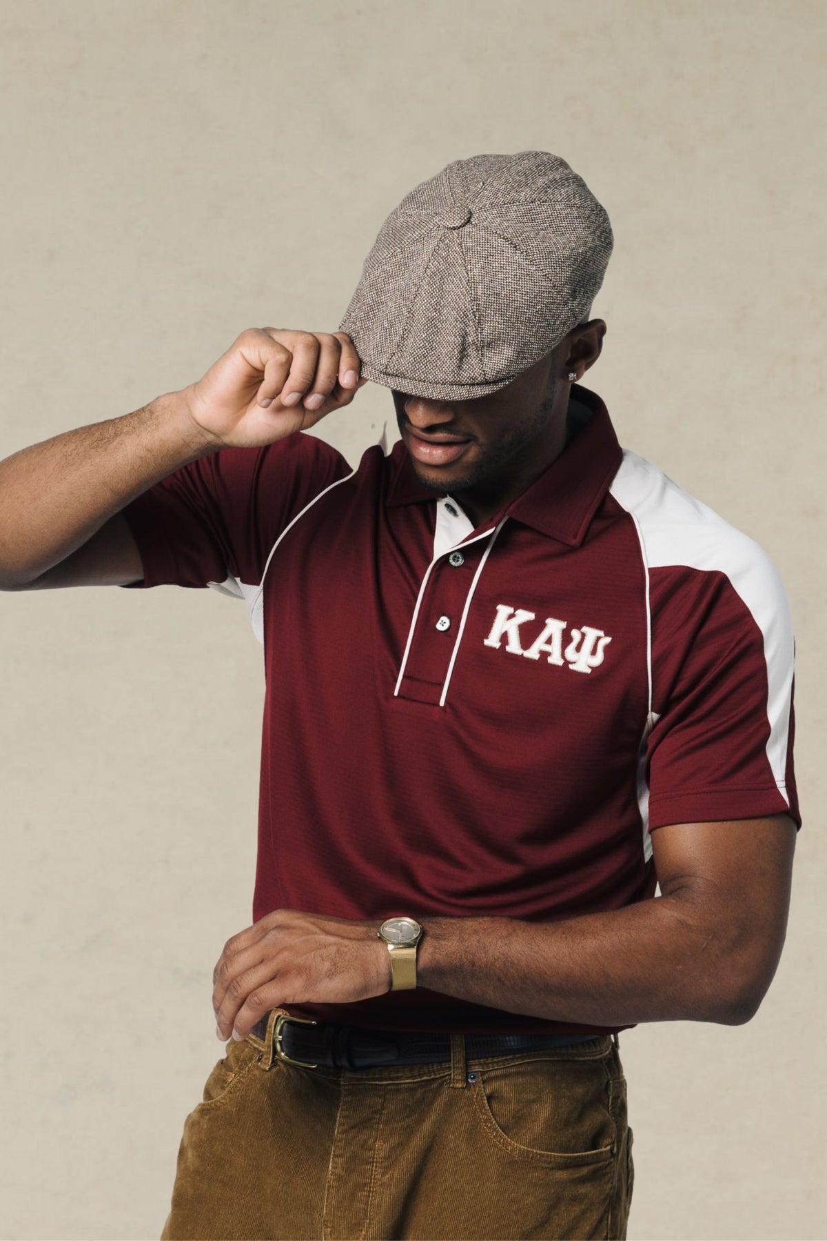 A man wearing a maroon and white DriFit polo shirt with Kappa Alpha Psi Greek Letter embroidery on the chest.